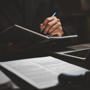 learning online class by using laptop computer and writing notebook at workplace