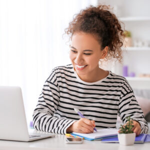 Young woman using laptop for online learning at home
