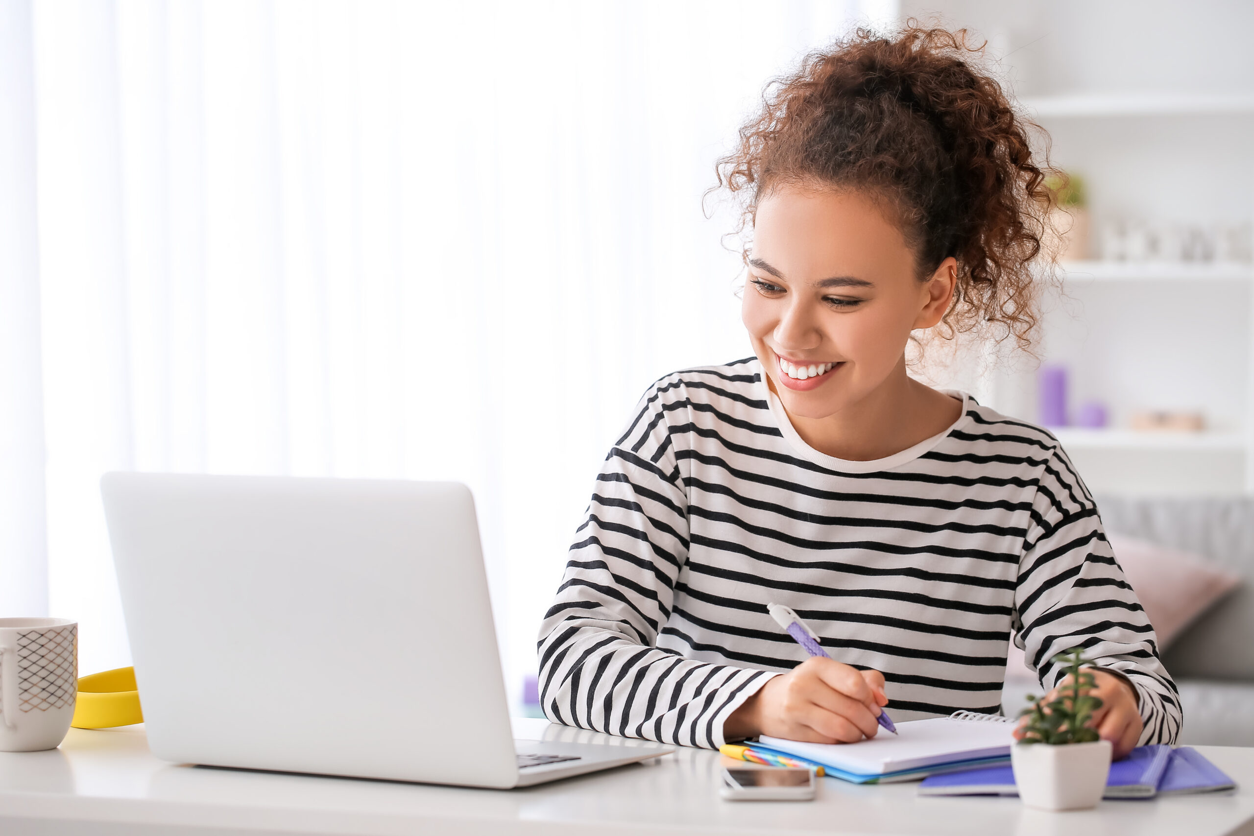 Young woman using laptop for online learning at home